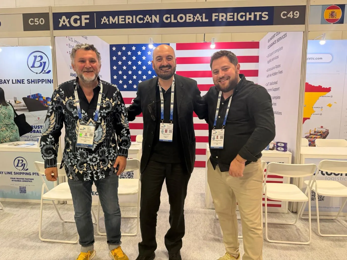AGF team members networking with WCA partners in front of the booth’s American flag backdrop